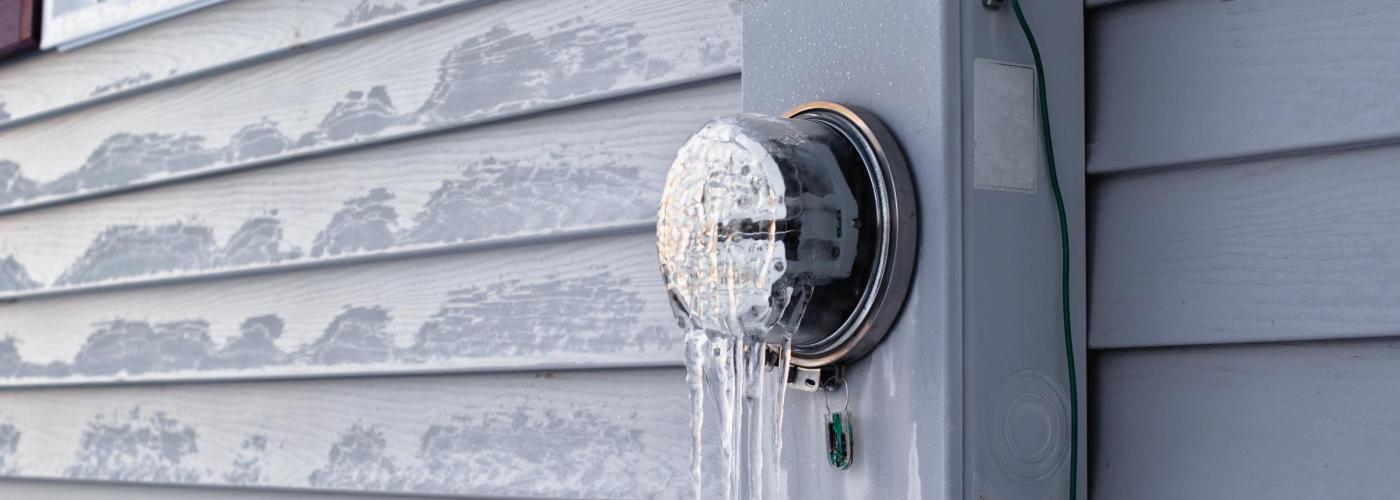 Electric meter with ice hanging from it. 